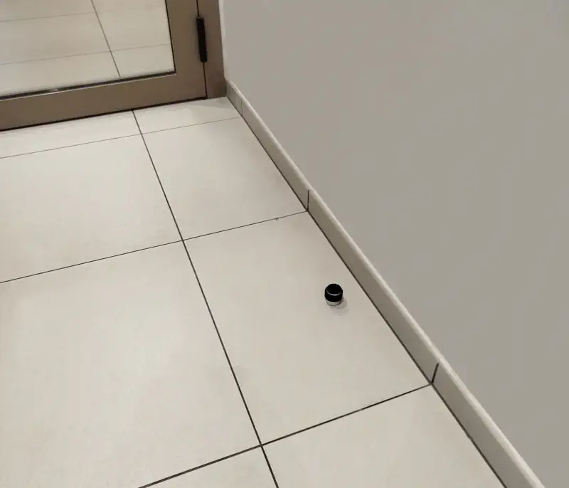 Butée de porte installée sur du carrelage solide.