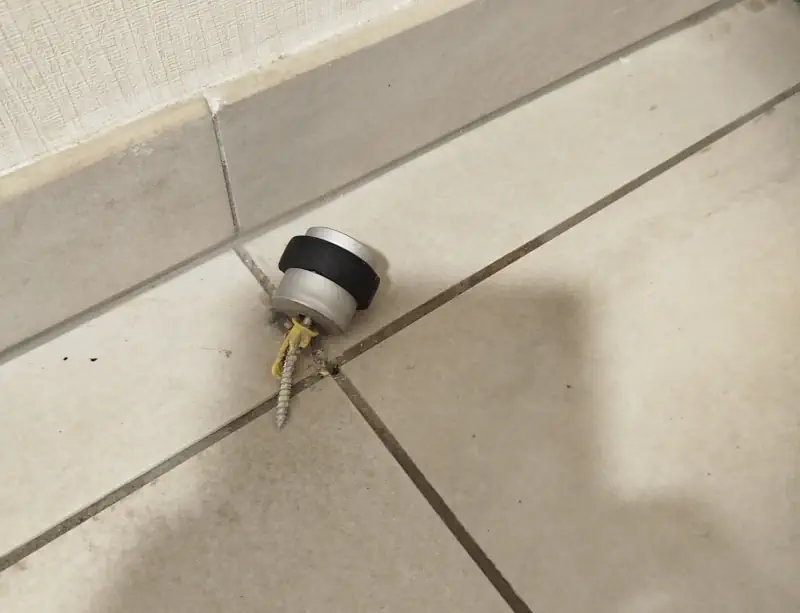 Butée de porte arrachée car mauvaise cheville dans le carrelage.