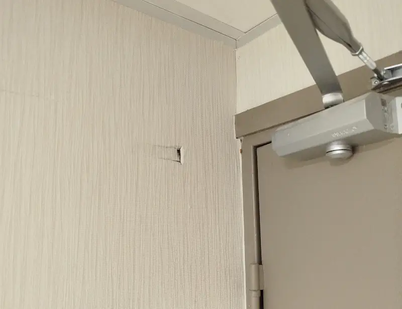 Un mur abimé suite aux ouvertures de portes brutales.